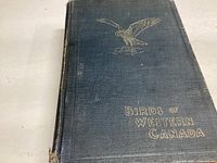 Front cover of the book showing the title 'Birds of Western Canada' with gold embossed bird illustration.