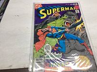 Superman comic book issue 324 in protective plastic sleeve showing cover art with Superman battling a giant green gorilla-like creature.