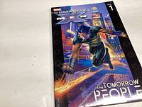 Photo showing the front cover of the Ultimate X-Men Volume 1 graphic novel featuring a superhero character in green with claws and a city background.