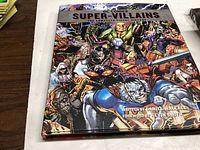Front cover of the DC Comics Super-Villains hardcover book with colorful villain artwork and title.