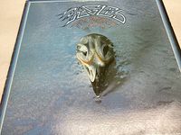 Front cover of the Eagles Greatest Hits vinyl record showing the iconic eagle skull design on a blue background.