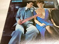 Front cover of Scorpions Love Drive vinyl record showing a man and woman in a car with stylized artwork.