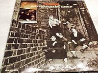 Front cover of The Who vinyl LP titled "Meaty Beaty Big and Bouncy" showing band members on brick steps