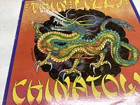 Front cover of Thin Lizzy Chinatown album featuring colorful coiled dragon artwork on a gradient background.