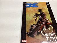 Photo of the front cover of Ultimate X-Men Vol 3 comic book showing a character sitting on a motorcycle with a brown and orange background.