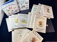 Group of 20 vintage Beatrix Potter books laid out, showing mostly white hardcover editions with colored character illustrations and black title text on front covers.
