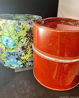 Two vintage ladies hat boxes: one floral fabric-covered and one brown leatherette with handle.
