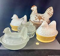 Group view of five nesting hen and swan dishes, showing size relative to a coin and overall condition.