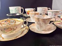 View showing variety of tea cups and mugs with floral, gold, and character designs