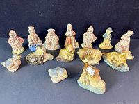 Group photo showing 14 Wade Tetley Tea collectible figurines arranged in rows, featuring human and animal figures with glazed ceramic finish.