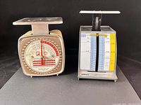Two vintage Canadian postal scales, one Pelouze Zephyr model with a round dial, the other with a sliding weight and postage chart.