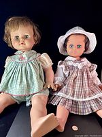 Both vintage dolls shown sitting side by side, showing full figures, clothing, and facial details, including the Ideal Kissy Face doll in gingham dress and her friend in plaid dress with hat.
