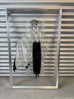 Full view of framed acrylic painting depicting a French woman in stylized attire standing with outstretched arms, in black and white against clear acrylic background.