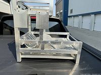 Side angled view of custom aluminum dish rack showing vertical utensil holders and plate slots