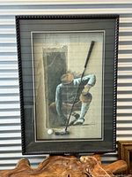 Front view of framed shadow box art showing golfer figure, mounted golf club, and golf ball under glass in black decorative frame.