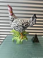 Front view of ceramic rooster figurine showing full body and base