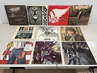 Front cover view of 12 classic rock vinyl records including Rare Earth, Santana, Aerosmith, Beatles, Dylan, and more.