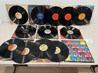 All vinyl records and albums arranged on table, showing front covers and vinyl surfaces.