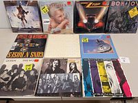 Front covers of 11 vinyl LP albums laid out on a table