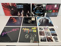 Photo of ten vinyl records with visible album covers arranged in two rows.