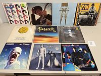 Top row of 10 vinyl album covers displayed on table showing front cover art for various artists.