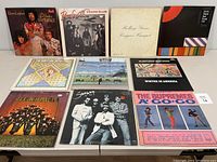 Photo showing front covers of all 10 vinyl albums arranged on a table.