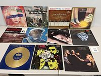 Photo showing front covers of 12 vinyl albums from various artists including Missing Persons, The Chambers Brothers, Lou Stein, ELO, Bob Dylan, Steve Winwood, and others.