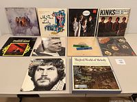Photo of 10 vinyl records arranged on table showing front covers and artists.