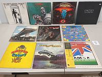 Front side of 10 vinyl LP album covers including Fleetwood Mac Rumours, Queen News of the World, Boston Boston, Eagles The Long Run, others.