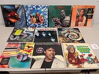 Front view of 9 vinyl records with original album covers laid out in 3 rows