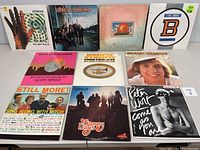 Front covers of eleven vinyl records from various artists arranged in three rows, showing album artwork including Genesis, Lynyrd Skynyrd, Allman Brothers Band, Bad Company, and others