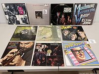 Top view of 10 vinyl records in their sleeves, showing front cover artwork for each album by artists including The Rolling Stones, The Beatles, Cream, Elton John, and others.