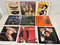 Photo of front covers of 9 vinyl LP records placed on white surface, showing artwork and titles from Rolling Stones, Emerson Lake & Palmer, Quentin Crisp, Dave Garroway, Eric Burdon & The Animals, Various Artists, The Cars, Tom Petty, The CS Angels.