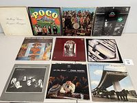 Front view of 11 vinyl albums, displaying cover art and condition. Includes whites, color, and detailed graphic covers.