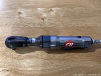 Side view of the Campbell Hausfeld air ratchet showing the metal body, 3/8 inch drive head, and airflow connection at the bottom.