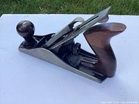 Stanley Bailey #4 smooth hand plane showing side angle with wooden knob and handle, metal body and blade assembly.