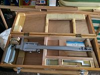 Top view of the Summit vernier gauge placed inside the fitted wooden case with foam padding.