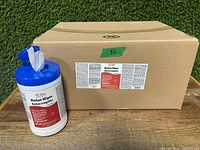 Photo shows a white plastic container with a blue lid dispensing a wipe, placed beside a cardboard case box labeled for 12 units of BioSan Wipes.