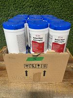 Front view of the open box containing 12 units of QT San BioSan Wipes, showing blue lids and labels.