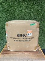 Manufacturer cardboard box with Qingdao Sinor Textile branding and handling labels, showing exterior packaging condition.