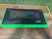 Photo of the closed retail box with Razer branding and Cynosa Chroma keyboard graphic on top.