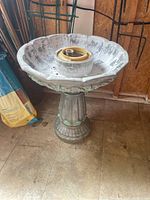 Full view of the composite bird bath showing the scalloped basin and pedestal base.