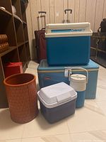 Five items: 3 coolers and 2 containers including vintage metal Coleman cooler and wicker style waste bin