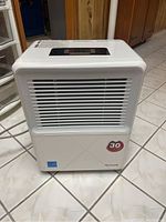 Front view of white Honeywell dehumidifier showing air vent grille and 30 pints capacity label