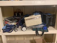 Overview of assorted bags including cooler bag, suitcase, and trolley on shelf