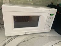 Full view of white Master Chef microwave with digital display and control buttons on the right side.