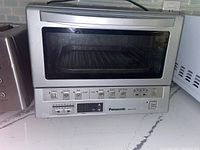Full front view of Panasonic toaster oven showing keypad and temperature control.