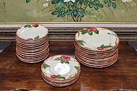 Stack of 10 dessert plates, 5 bread plates, and 14 saucers showing apple and leaf pattern on edges