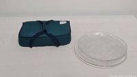 Photo of all glass serving dishes with insulated teal and navy blue carry case on a white background