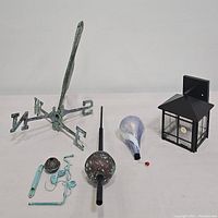 Full lot image showing all items: antique copper pelican weathervane with N,S,E,W markers, spherical copper finial, glass raindrop ornament, black metal outdoor light cover, and mounting hardware.